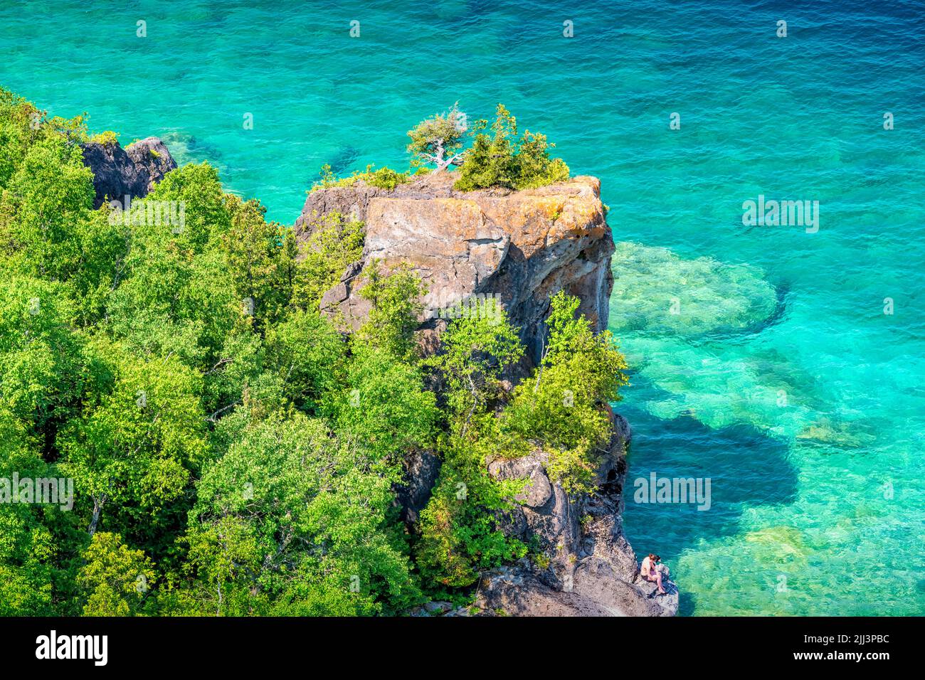 Donna siede sulle rive del Lago Huron nella penisola di Bruce, Georgian Bay, Ontario, Canada. Foto Stock