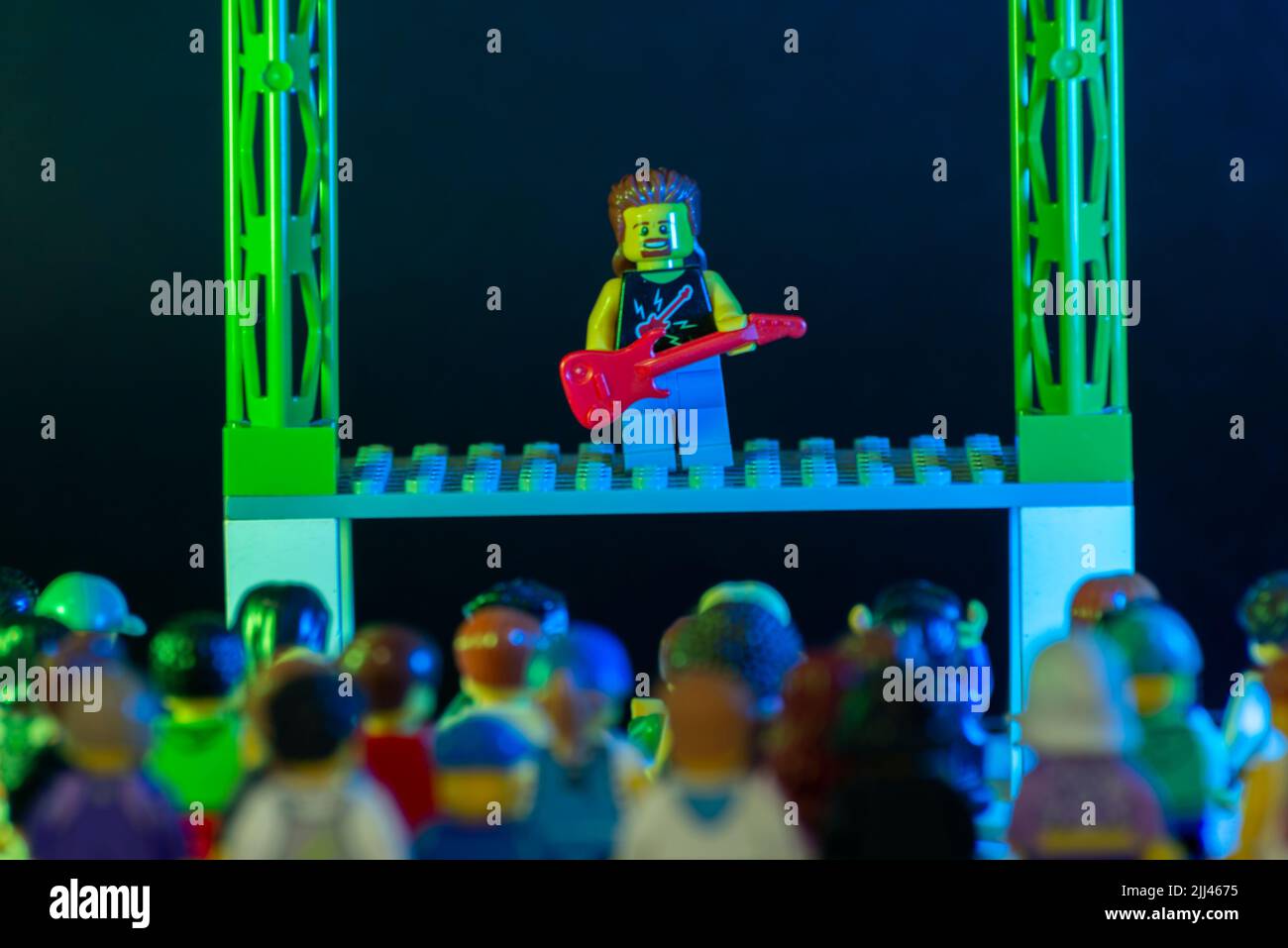 Bauru, Brasile. 1 giugno 2022: Minifigura LEGO rock star suonando la chitarra e eseguendo un concerto solista sul palco con migliaia di spettatori che guardano e. Foto Stock