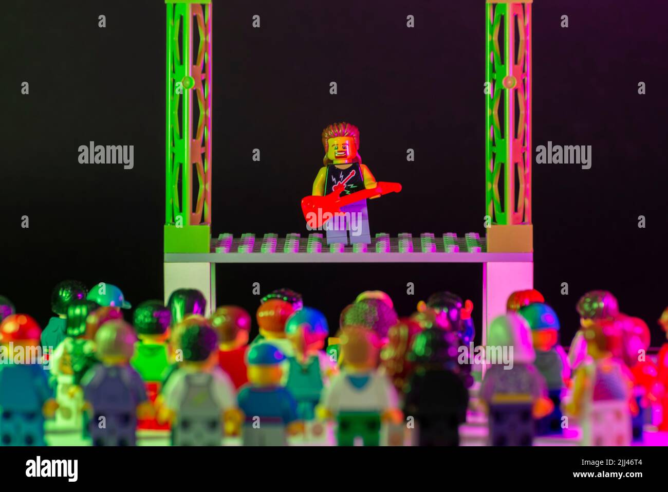 Bauru, Brasile. 1 giugno 2022: Minifigura LEGO rock star suonando la chitarra e eseguendo un concerto solista sul palco con migliaia di spettatori che guardano e. Foto Stock Bauru, Brasile. 1 giugno 2022: Minifigura LEGO rock star suonando la chitarra e eseguendo un concerto solista sul palco con migliaia di spettatori che guardano e. Foto Stock