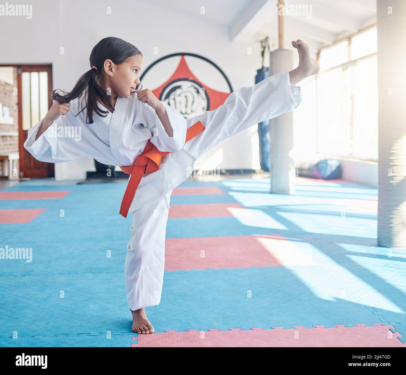 La vostra mente è la vostra arma più potente. Una ragazza piccola carina che pratica il karate in uno studio. Foto Stock