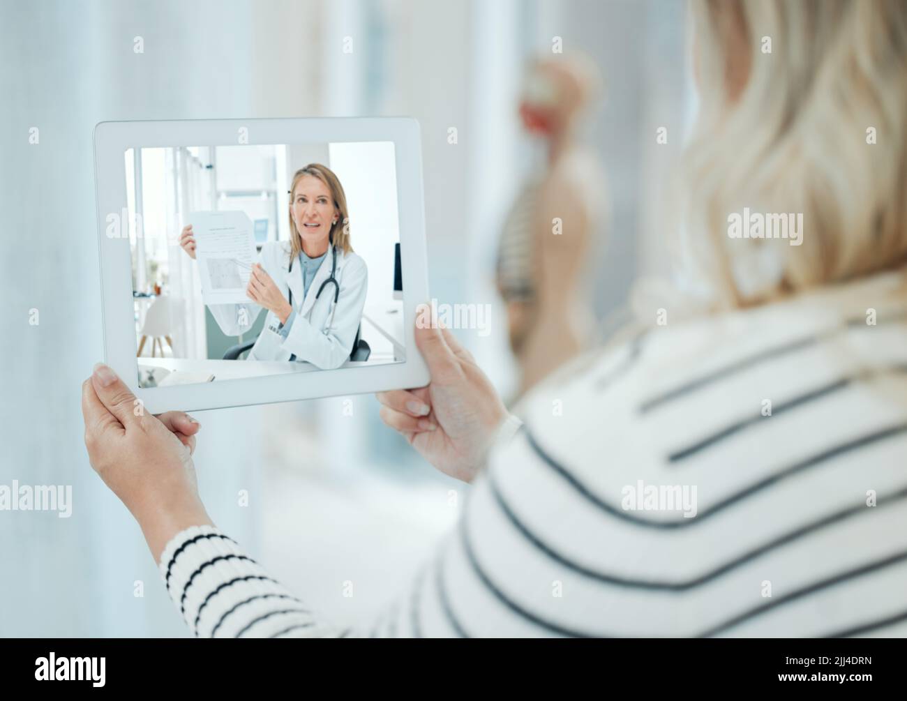 Ogni paziente porta dentro di sé il proprio medico, una donna irriconoscibile che usa un tablet digitale a casa. Foto Stock