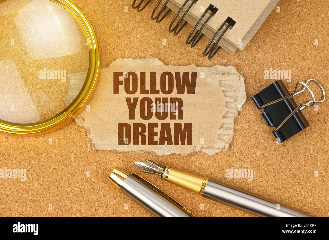 Concetto di business e finanza. Sul tavolo ci sono oggetti da ufficio e un cartone con l'iscrizione - SEGUITE IL VOSTRO SOGNO Foto Stock