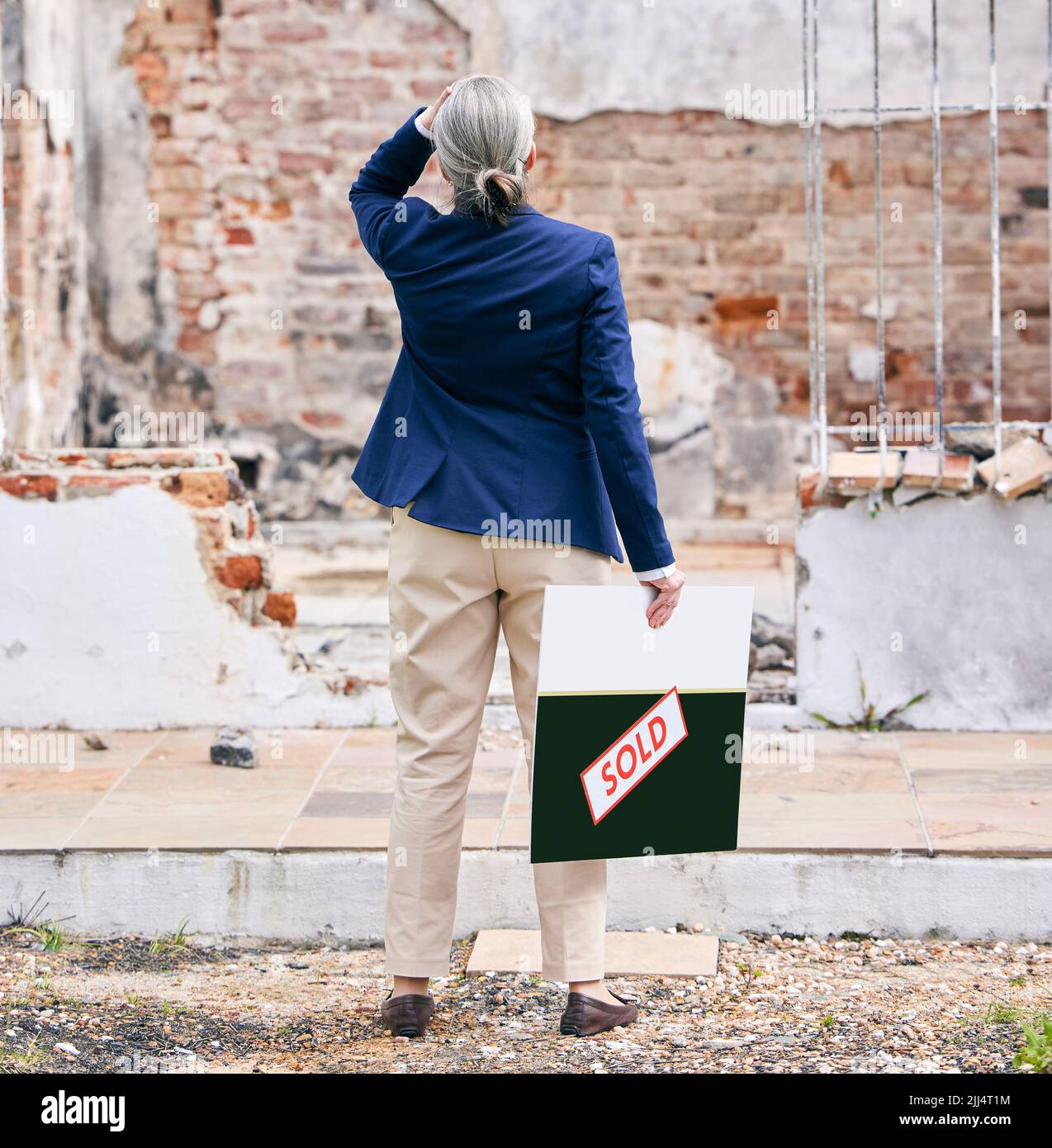 Le lacrime sono il linguaggio silenzioso del dolore, un immobile che si trova fuori da una proprietà bruciata. Foto Stock