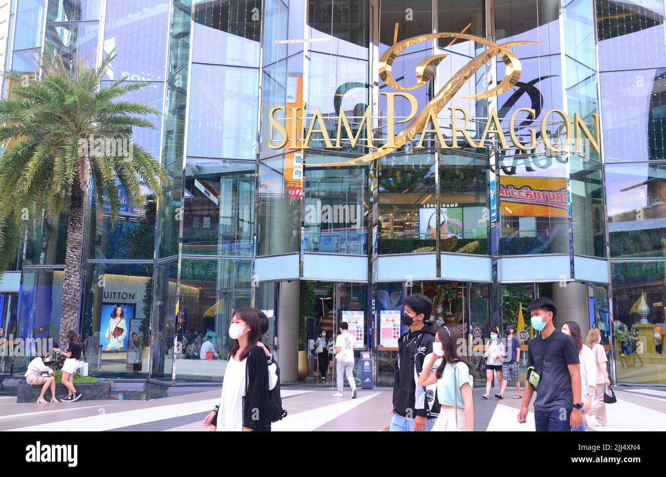 Nonostante il rilassamento ufficiale delle regole la maggior parte della gente ancora indossa le maschere nella strada in luglio, 2022, come passano il centro commerciale di Siam Paragon, il distretto di Pathumwan, Bangkok, Tailandia, Asia. Foto Stock