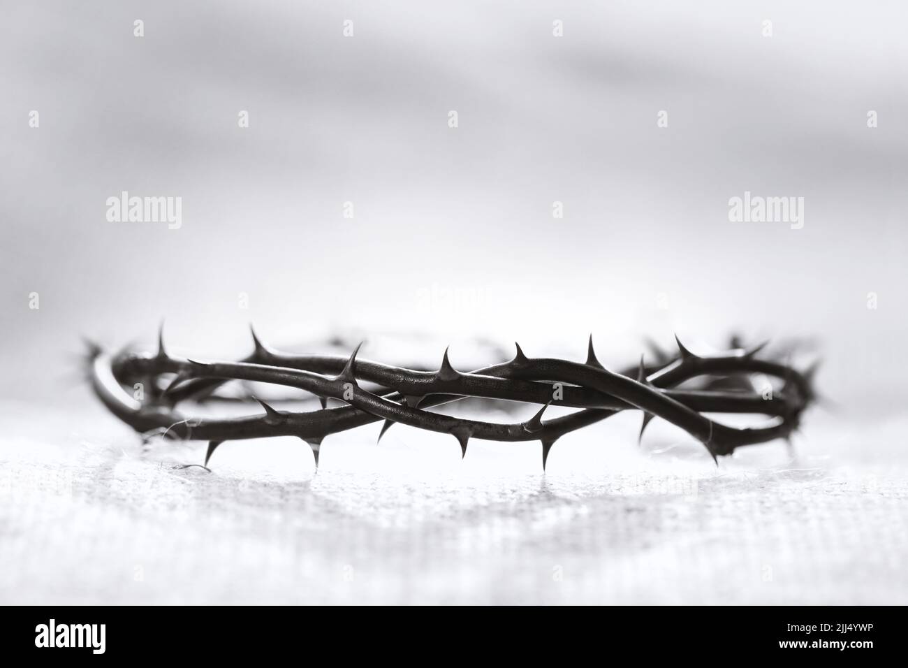 Corona di spine che simboleggia il sacrificio, la sofferenza e la risurrezione di Gesù Cristo sulla croce e sullo sfondo della luce pasquale Foto Stock