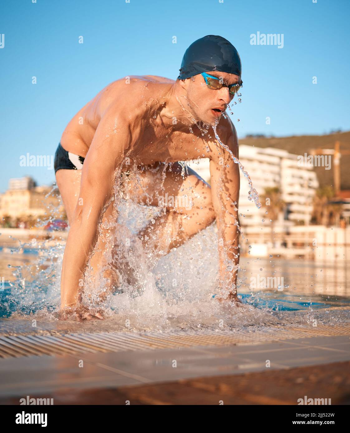 Ha schiacciato quel giro. Un bel giovane atleta maschio che nuotava in una piscina olimpionica. Foto Stock