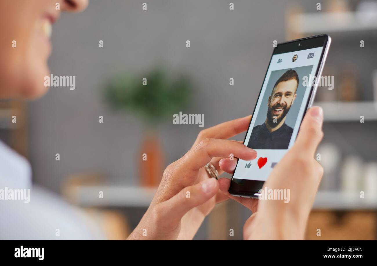 Donna sorridente che ama scattare foto sui social media o scorrere l'app di incontri online. Foto Stock