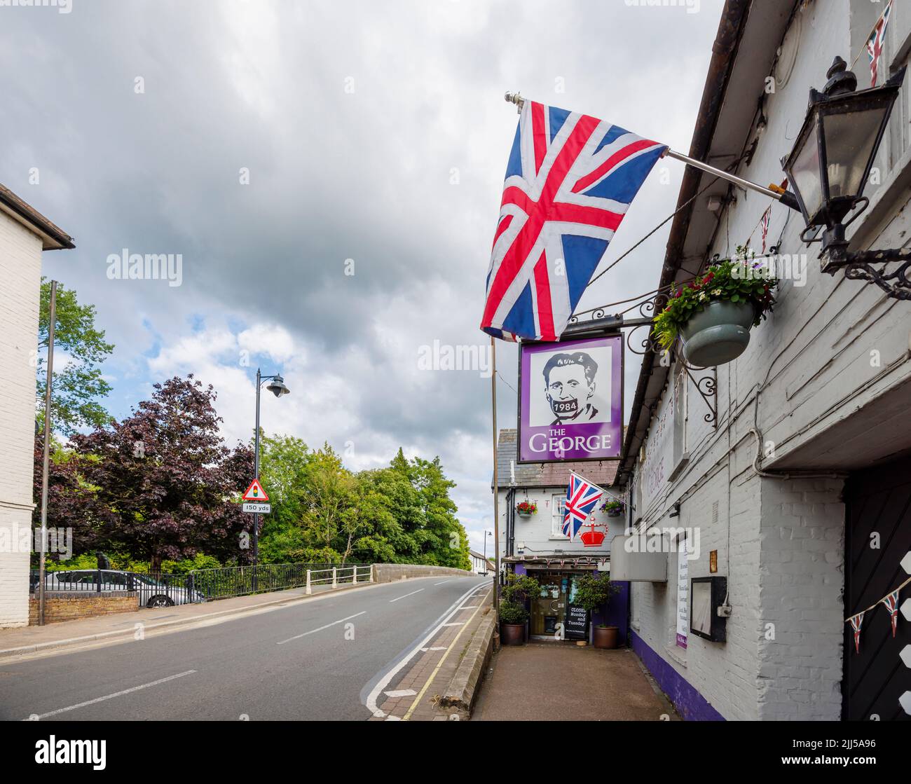 The George, un pub sulla strada con un cartello George Orwell 1984 e la bandiera Union Jack a Fordingbridge, un piccolo villaggio nella New Forest, Hampshire Foto Stock