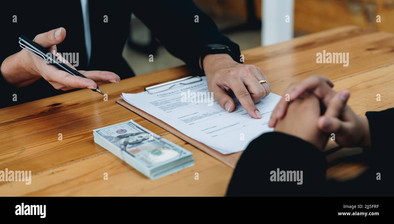la gente firma il contratto per prendere in prestito i soldi dall'investitore per investire al proprio business. prestito ipotecario concetto di finanziamento. Foto Stock