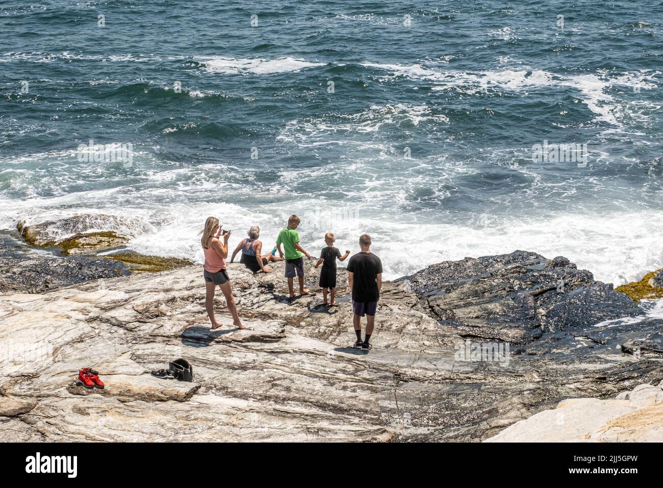 La famiglia si diverte con le onde dell'oceano al Beaver Tail state Park a Jamestown, Rhode Island Foto Stock