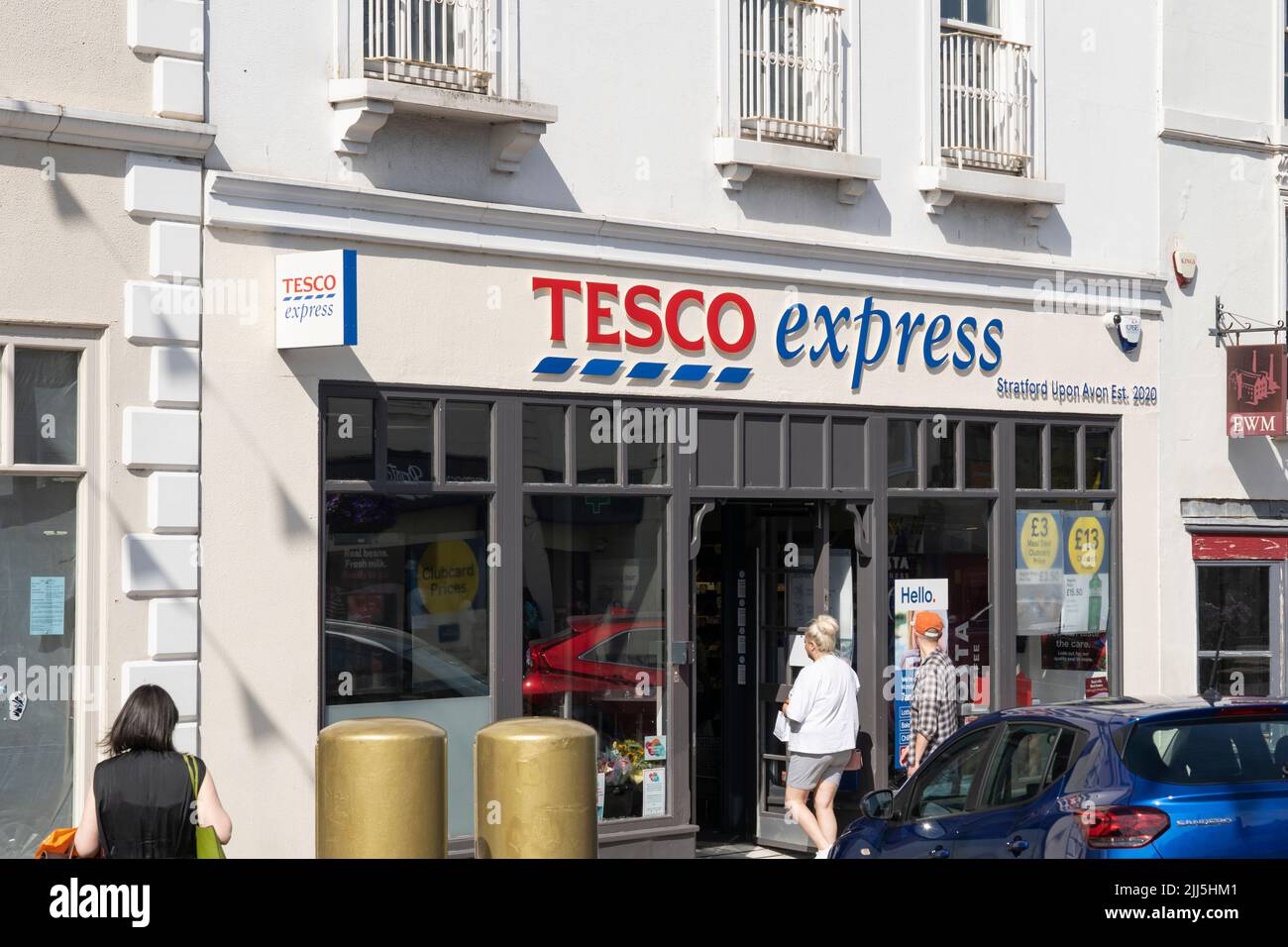 Gli acquirenti entrano in un Tesco Express su Bridge Street a Stratford upon Avon, Inghilterra. Concetto - costo della vita, shopping alimentare, aumento dell'inflazione Foto Stock