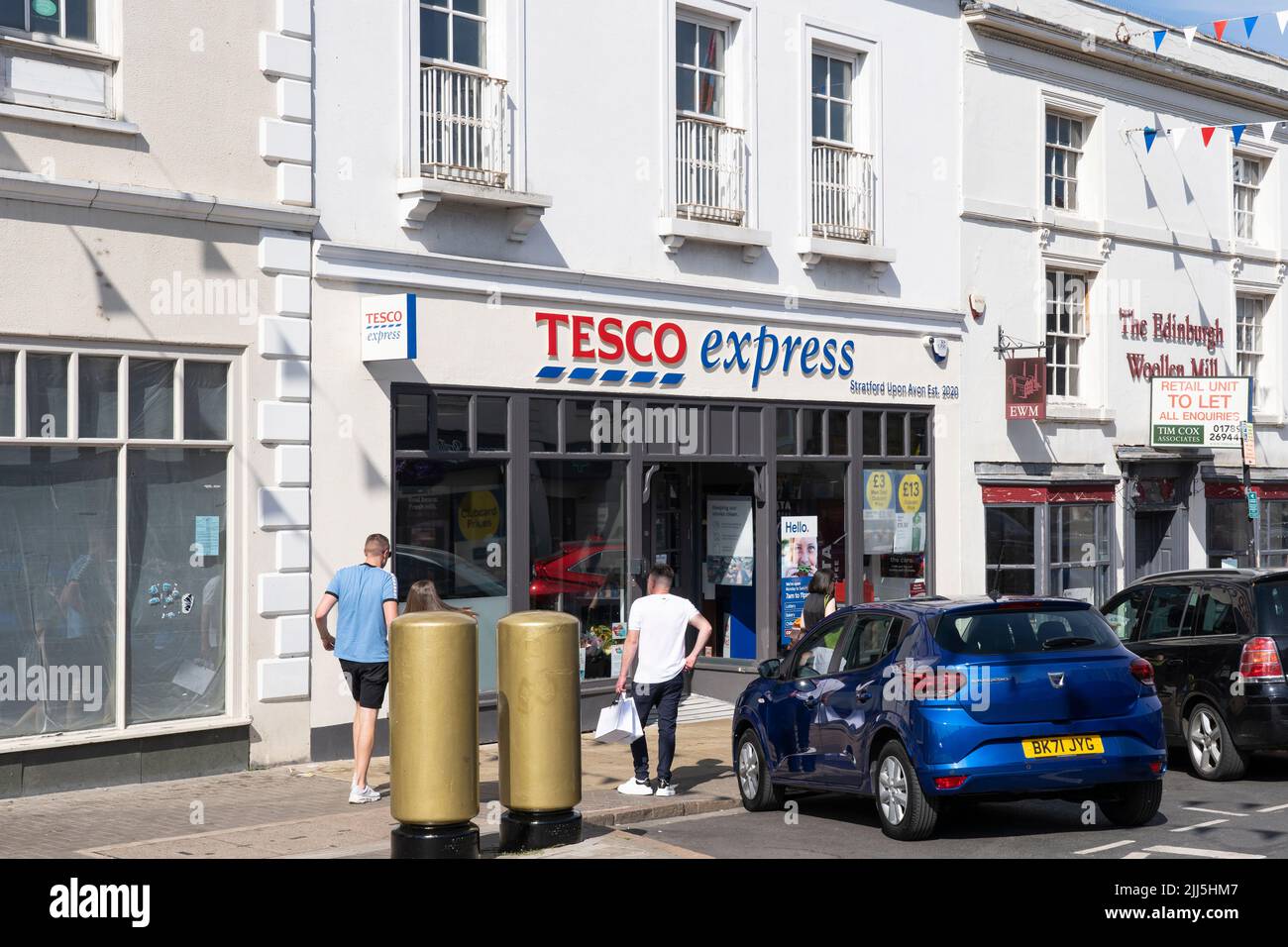 Gli acquirenti entrano in un Tesco Express su Bridge Street a Stratford upon Avon, Inghilterra. Concetto - costo della vita, shopping alimentare, aumento dell'inflazione Foto Stock