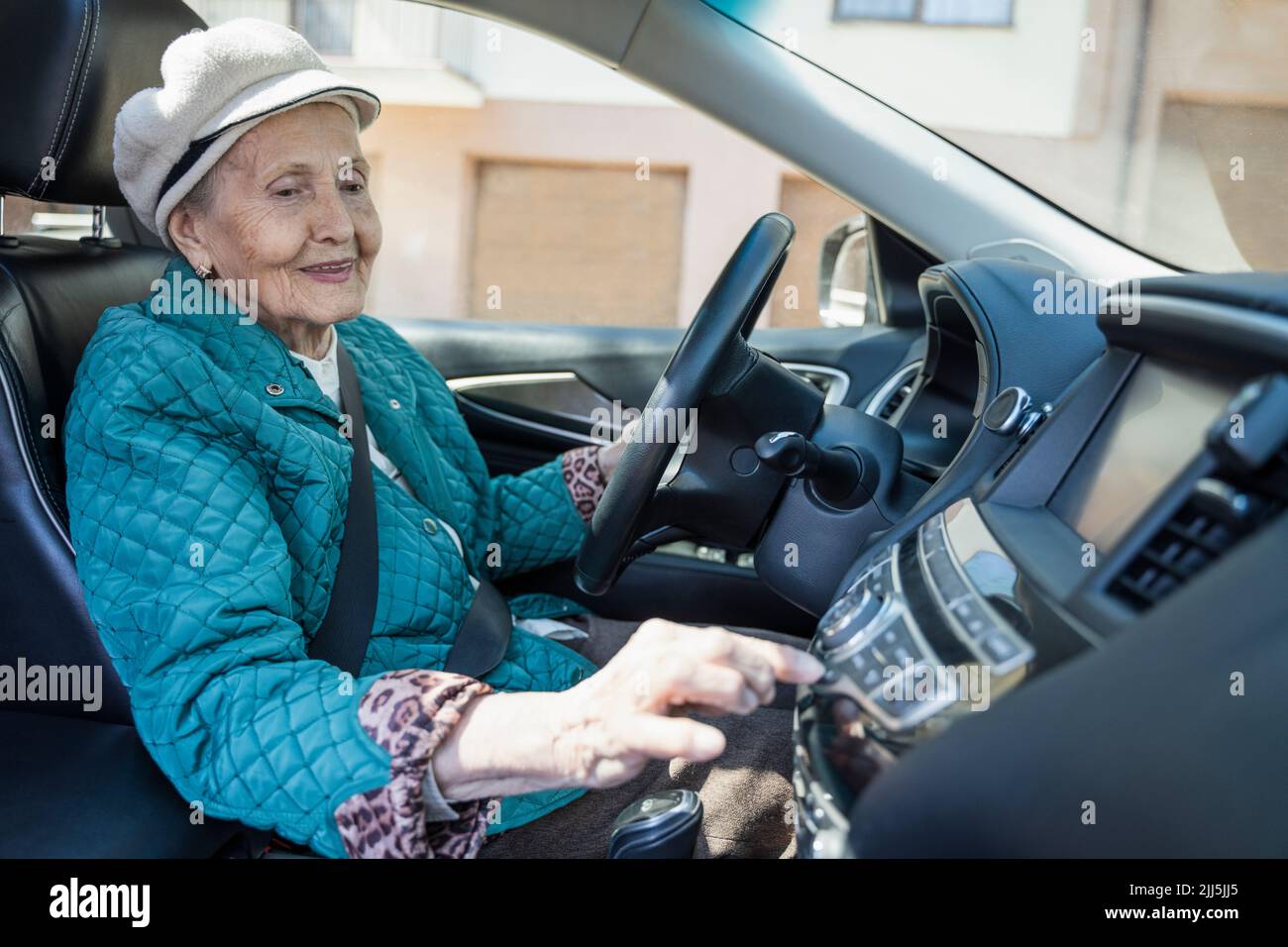 Donna anziana sorridente che suona musica sull'autoradio Foto Stock