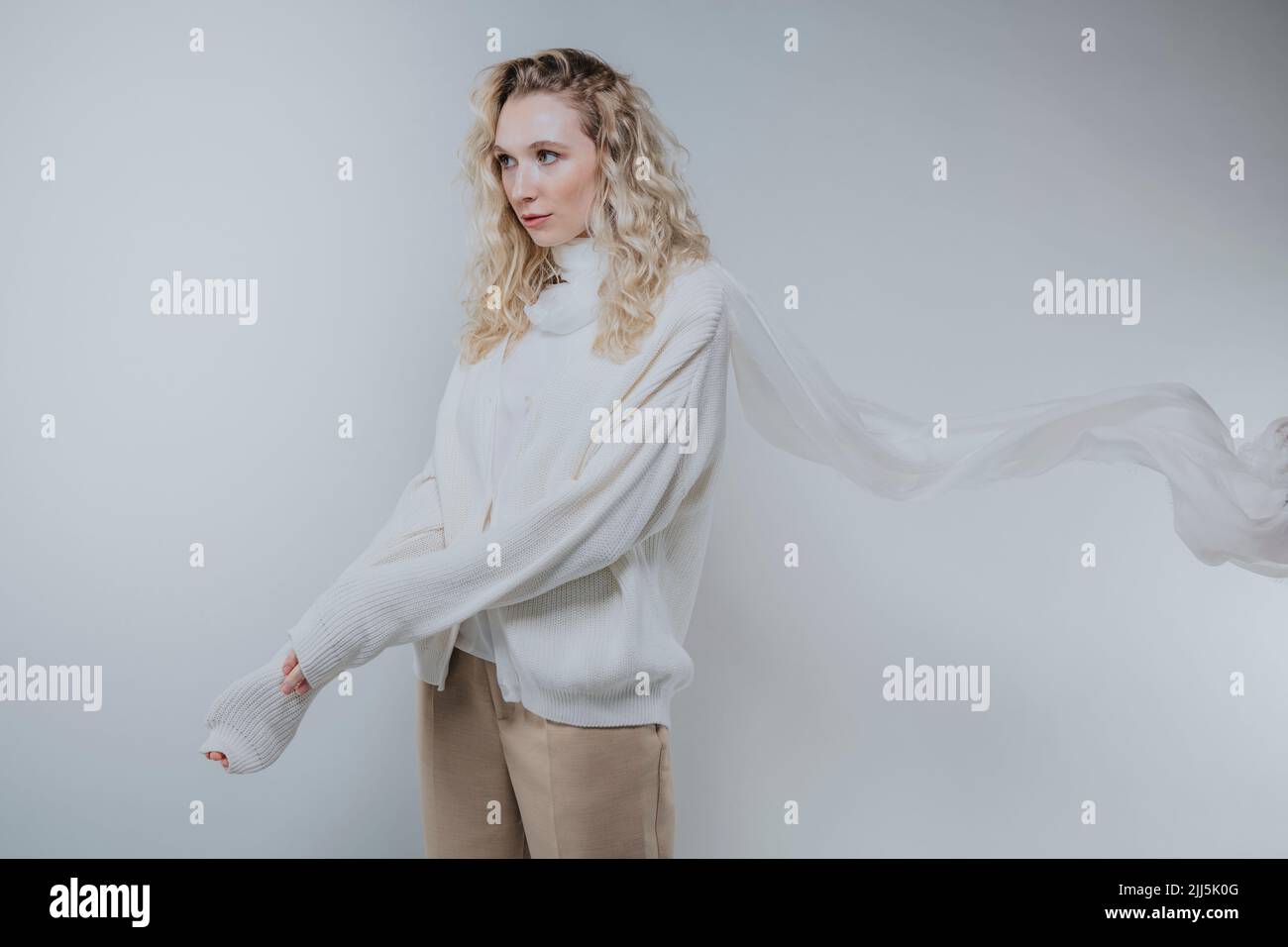 Giovane donna che indossa abiti bianchi su sfondo bianco Foto Stock