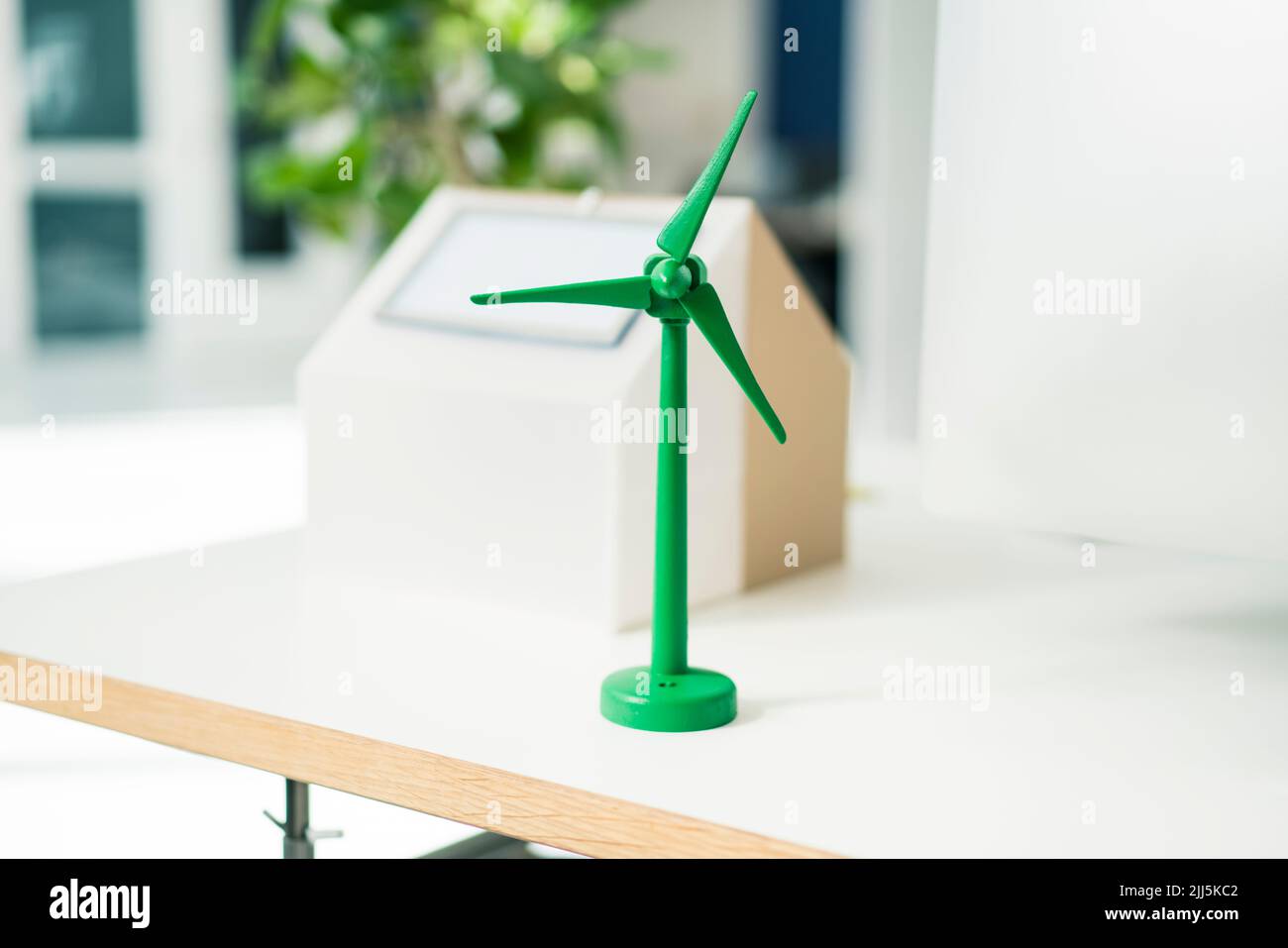 Modello di turbina eolica e casa con pannelli solari su scrivania in ufficio Foto Stock Modello di turbina eolica e casa con pannelli solari su scrivania in ufficio Foto Stock