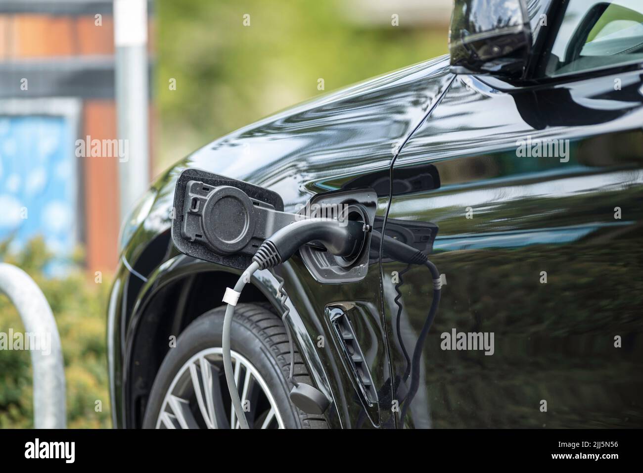 Un'auto nera con spina di ricarica Foto Stock