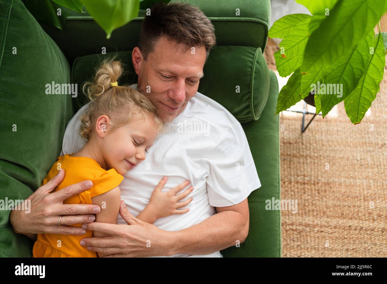 Padre e figlia si rilassano sul divano di casa Foto Stock