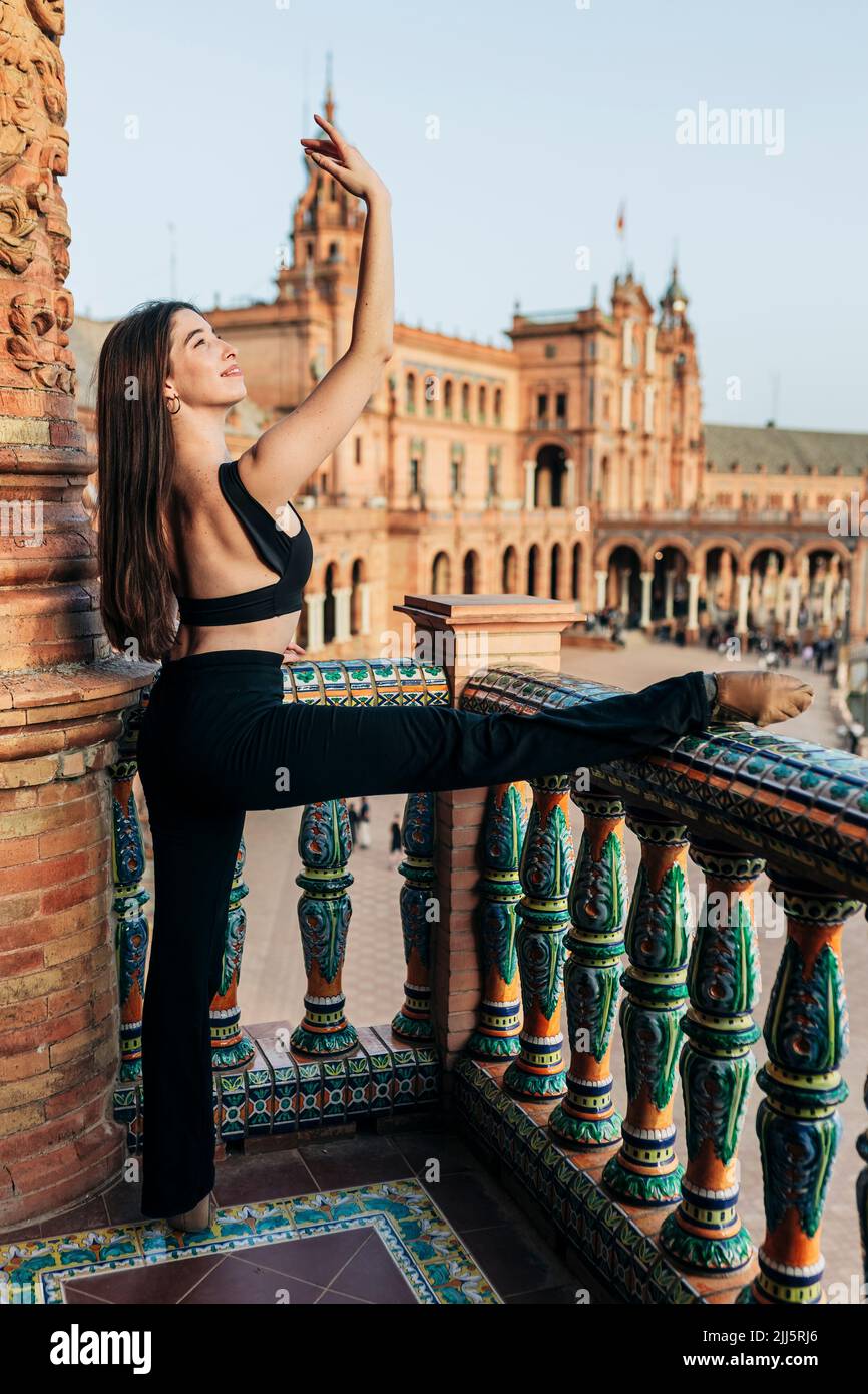 Ballerina aggraziata in equilibrio su una gamba sul balcone storico Foto Stock Ballerina aggraziata in equilibrio su una gamba sul balcone storico Foto Stock