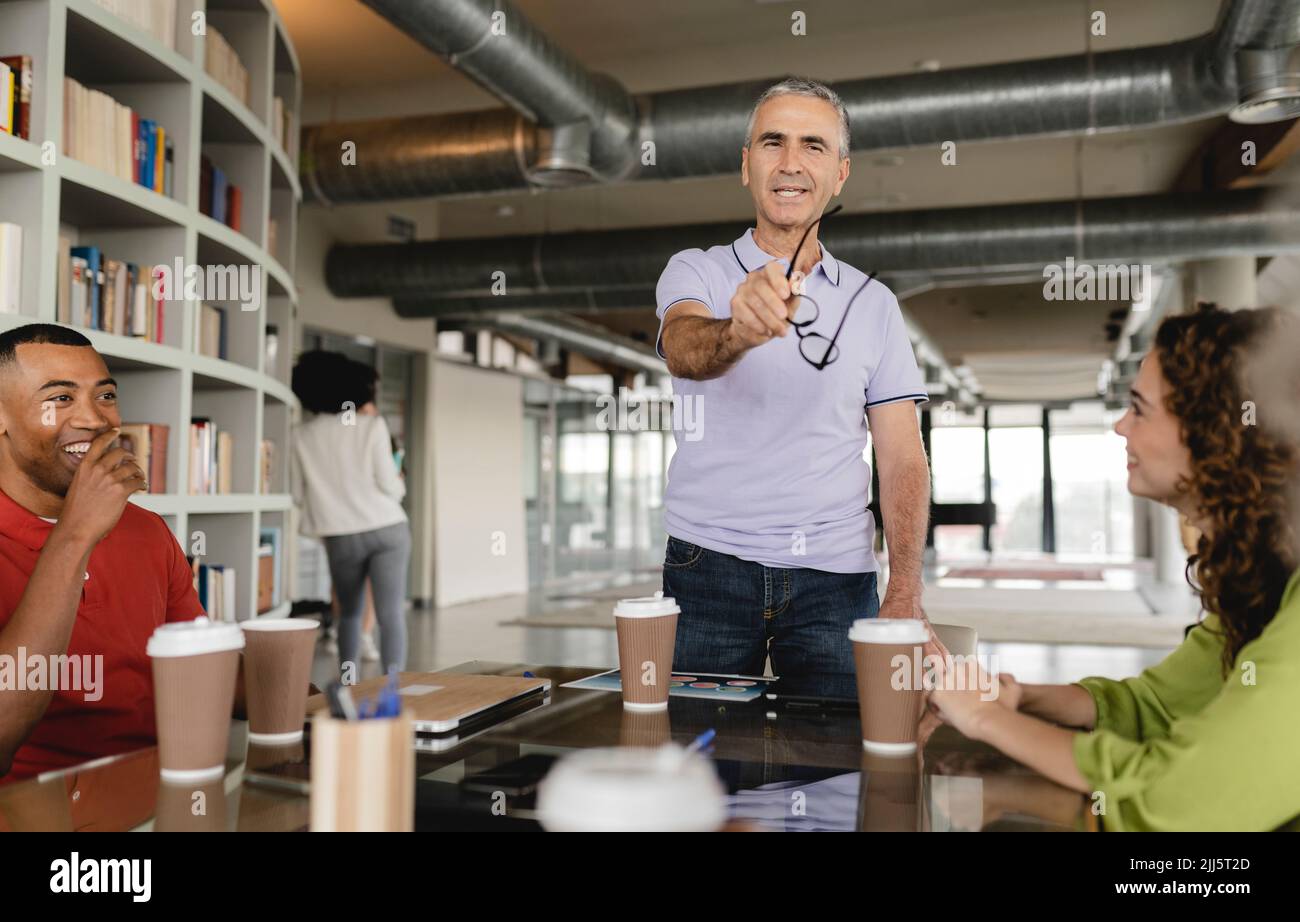 Felice uomo d'affari in riunione con i colleghi in ufficio Foto Stock