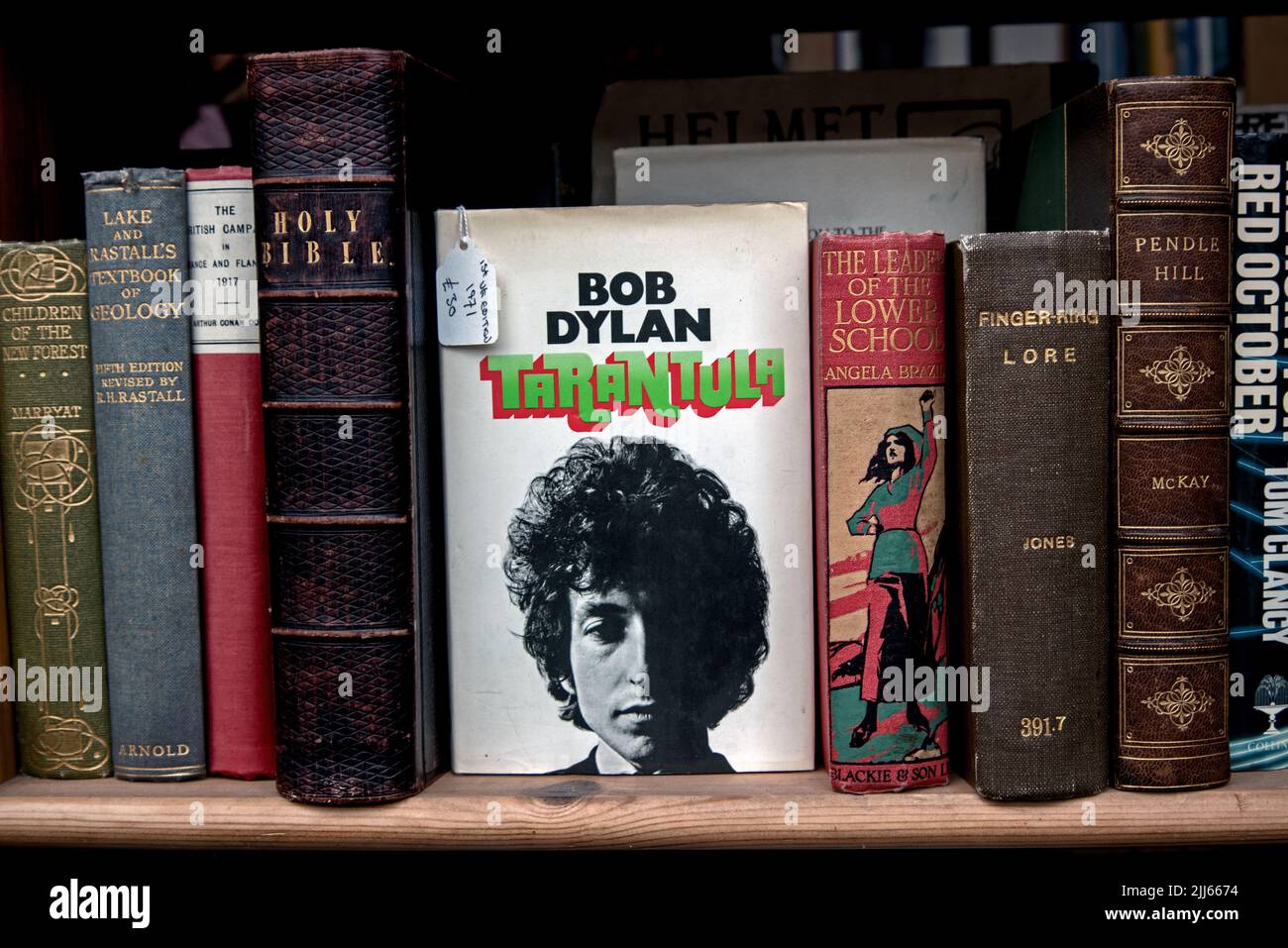 Prima edizione di Tarantula di Bob Dylan sullo scaffale di una libreria secondaria accanto ad altri libri d'epoca, inclusa una copia della Bibbia. Foto Stock