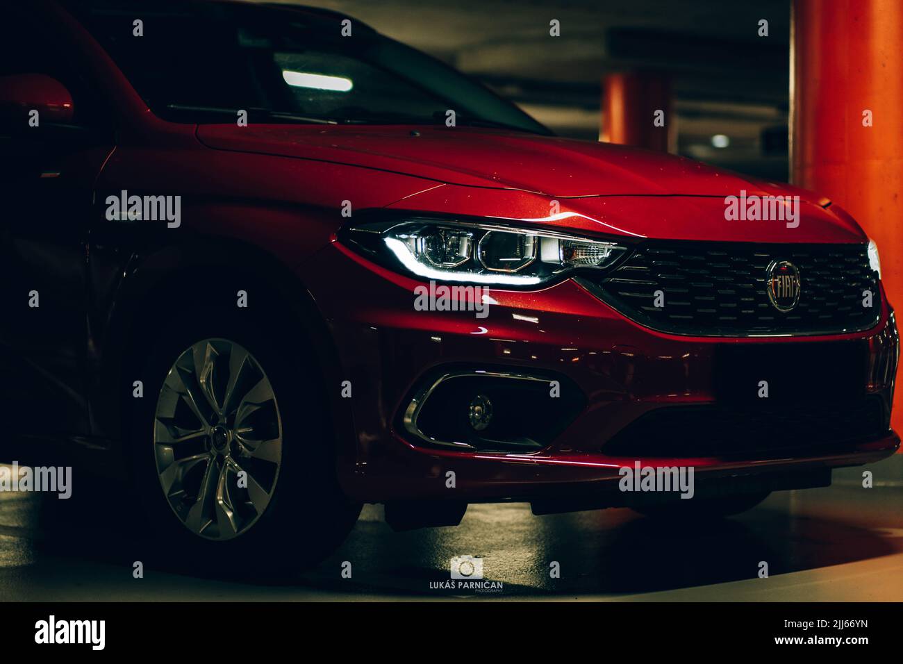Bella fiat tipo rossa parcheggiata in un garage scuro con splendide luci anteriori e posteriori in piombo. Foto Stock