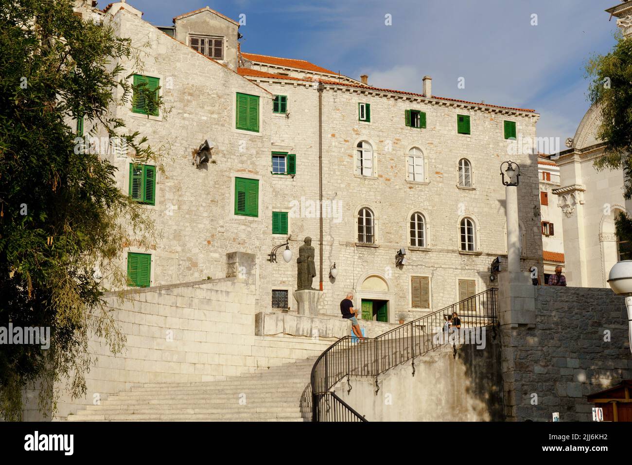 Una bella foto di una vecchia casa in pietra con finestre verdi a Sibenik, Croazia Foto Stock