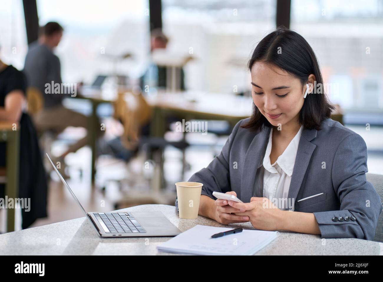 Giovane donna d'affari asiatica che usa lo smartphone al lavoro. Banner Foto Stock