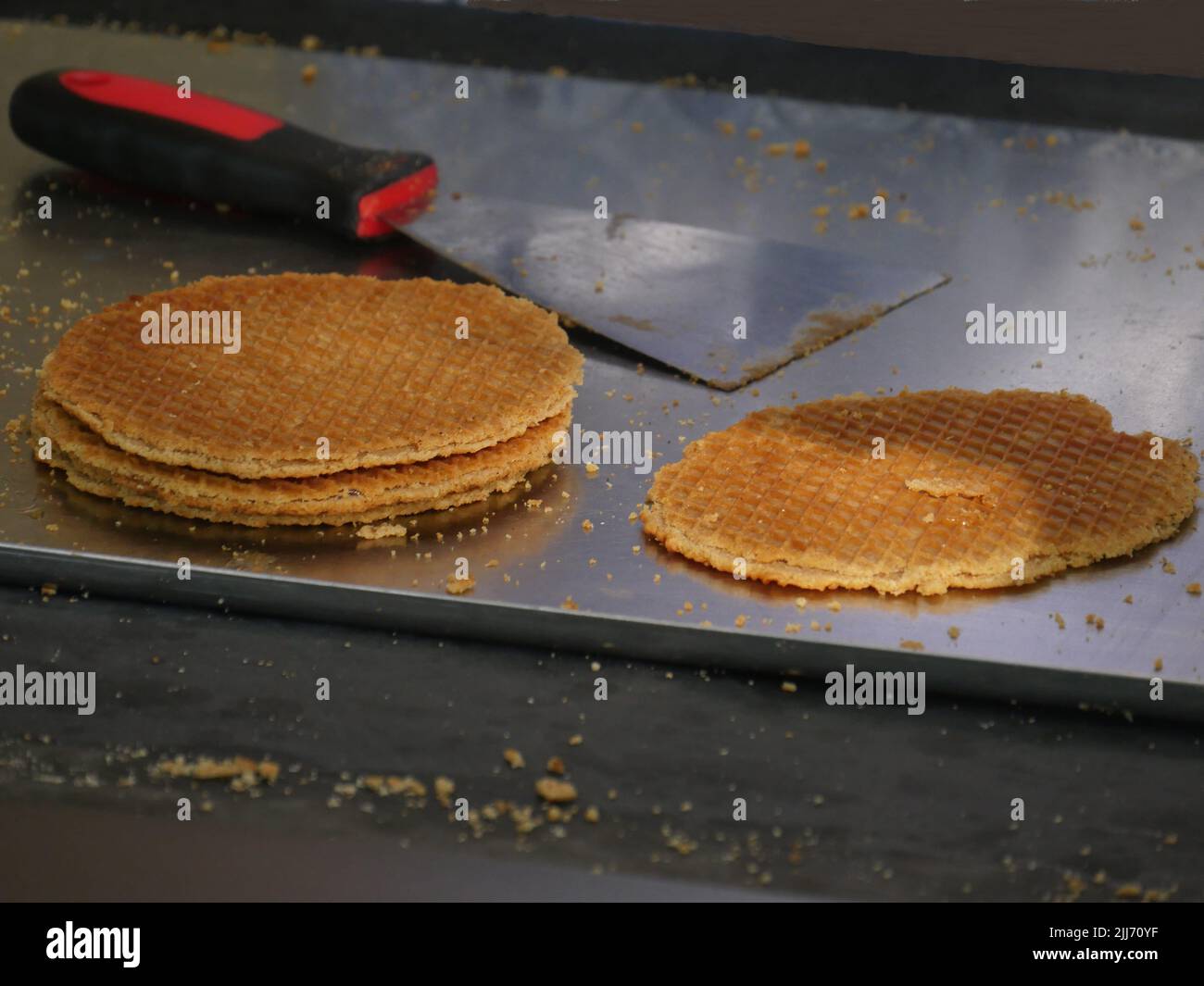 Sfoglia con le briciole di pasta, i waffle Stroop appena sfornati, in stile olandese, sullo sfondo sfocato un lifter per sollevare i waffle Foto Stock