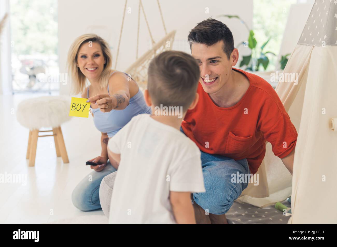 I giovani genitori sorprendono il loro bambino con una rivelazione di genere del loro secondo bambino. Concetto di relazioni sane. Famiglia in crescita. Foto di alta qualità Foto Stock