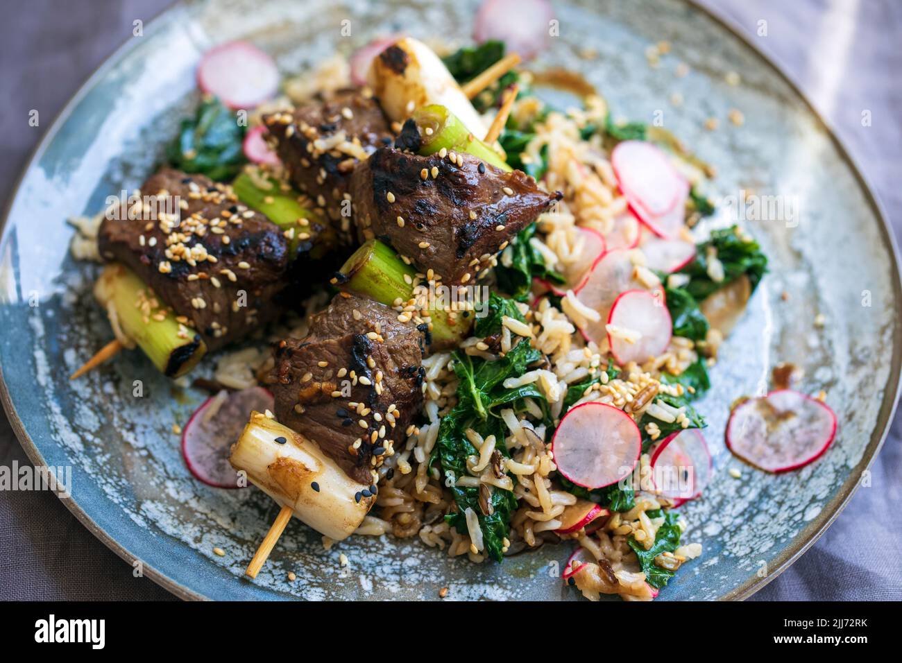 Spiedini di manzo con riso, kale e ravanelli Foto Stock