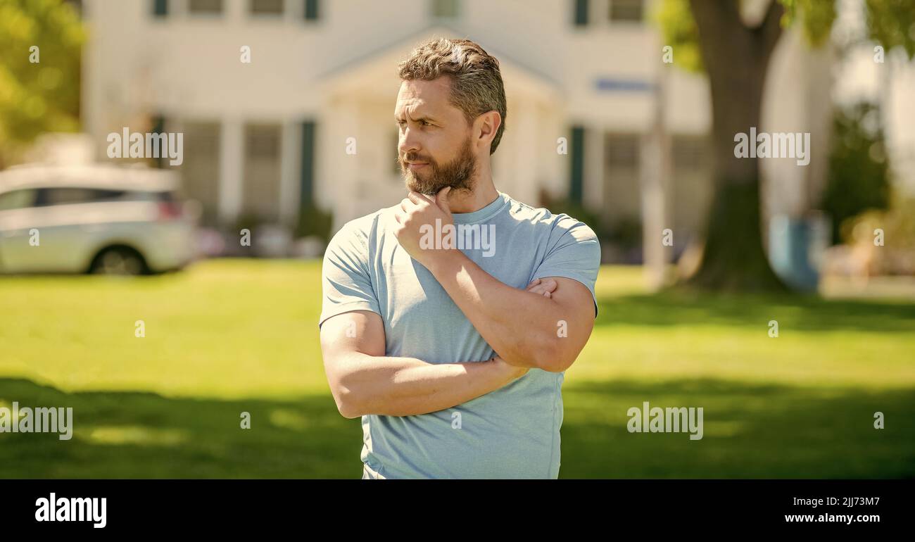 serio uomo maturo realtor in piedi all'aperto a casa, broker Foto Stock