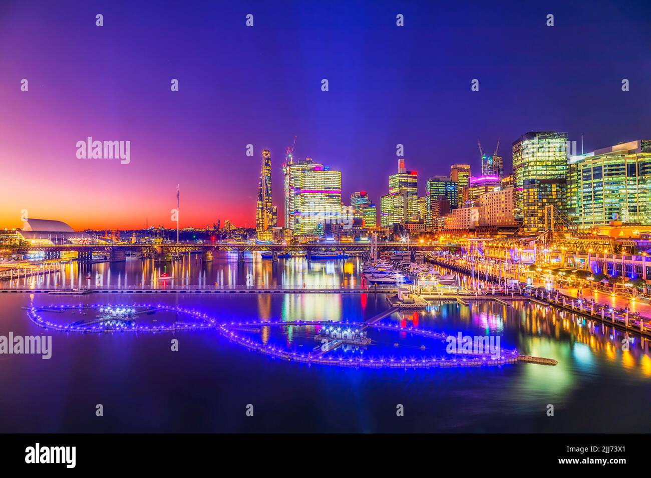 Darling Harbour City of Sydney CBD alti edifici sul lungomare al tramonto con luci luminose. Foto Stock