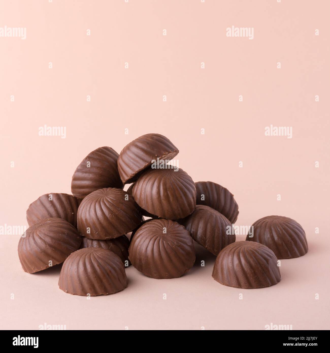 mucchio di caramelle al cioccolato o dolci, su sfondo più leggero, primo piano Foto Stock