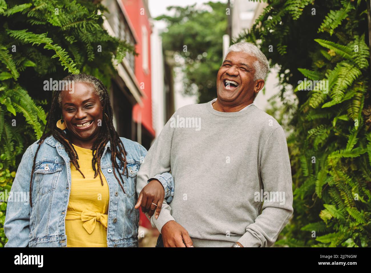 Una coppia romantica che ride allegro mentre si cammina insieme all'aperto. Coppia anziana felice che spende un certo tempo di qualità insieme dopo il pensionamento. Foto Stock