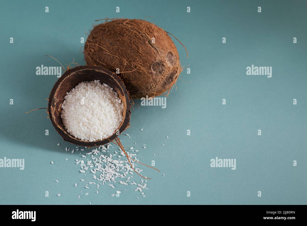 Cocco intero con scaglie di cocco su sfondo blu Foto Stock