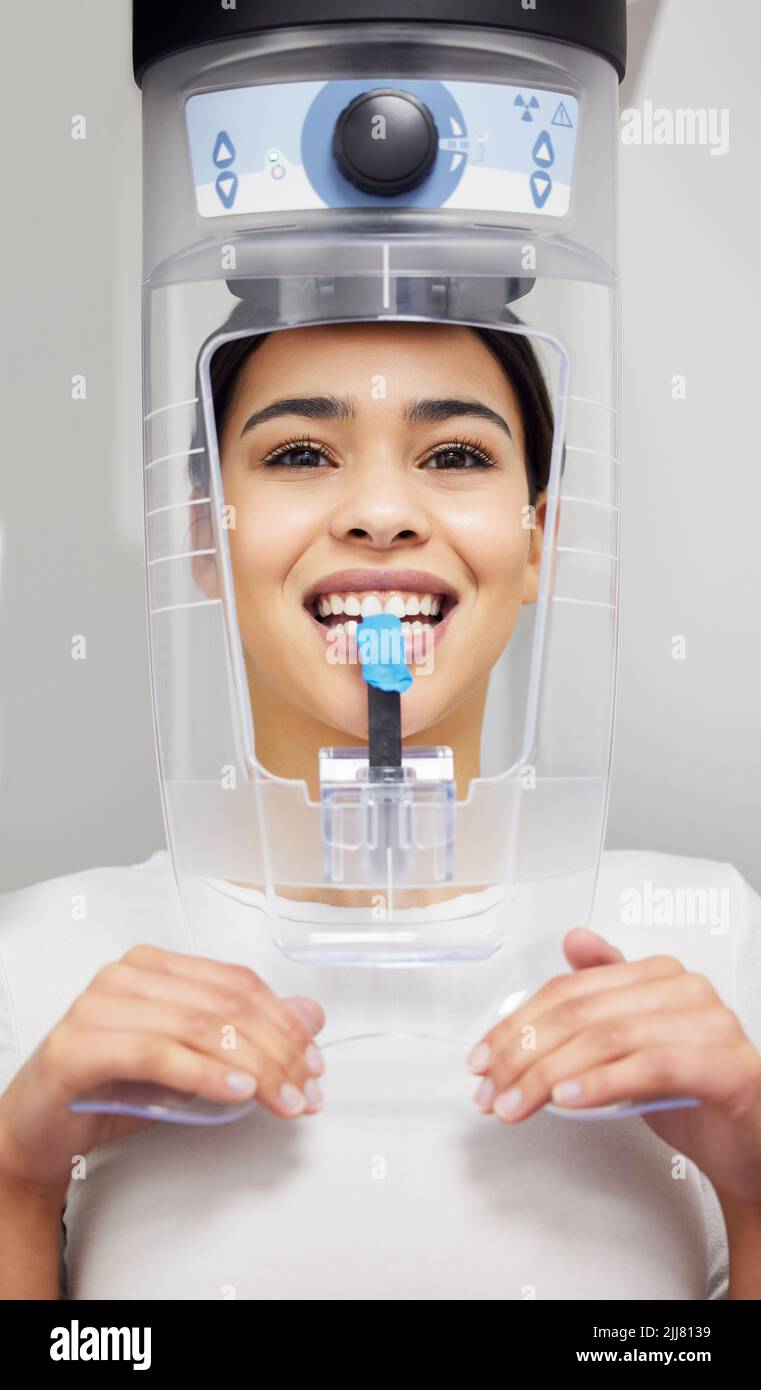 I raggi X sono una procedura standard presso il dentista. Una giovane donna che utilizza una macchina a raggi X in un ufficio dentistico. Foto Stock