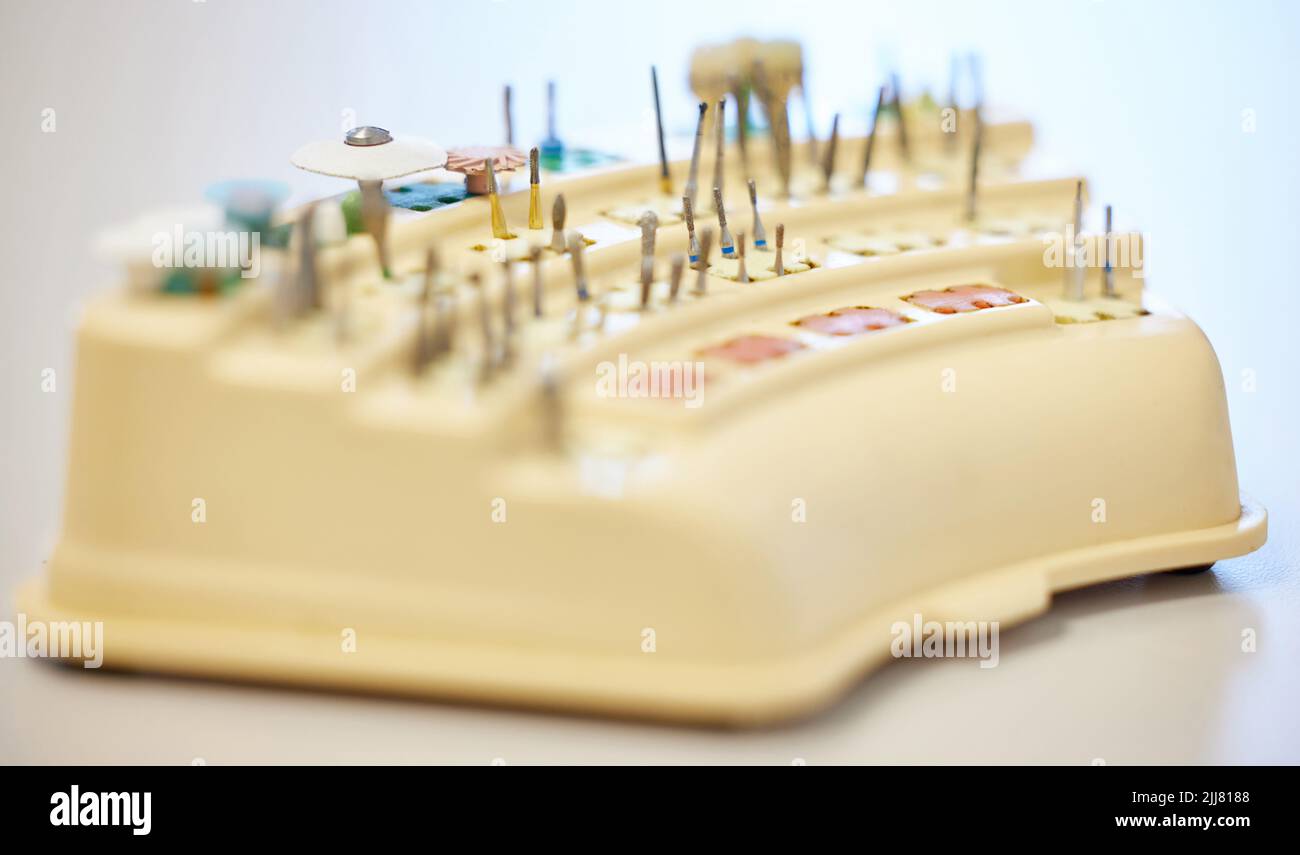 Presto a una pulizia dei denti vicino a voi. Vari attrezzi per la pulizia dei denti su un tavolo in un ufficio dentistico. Foto Stock