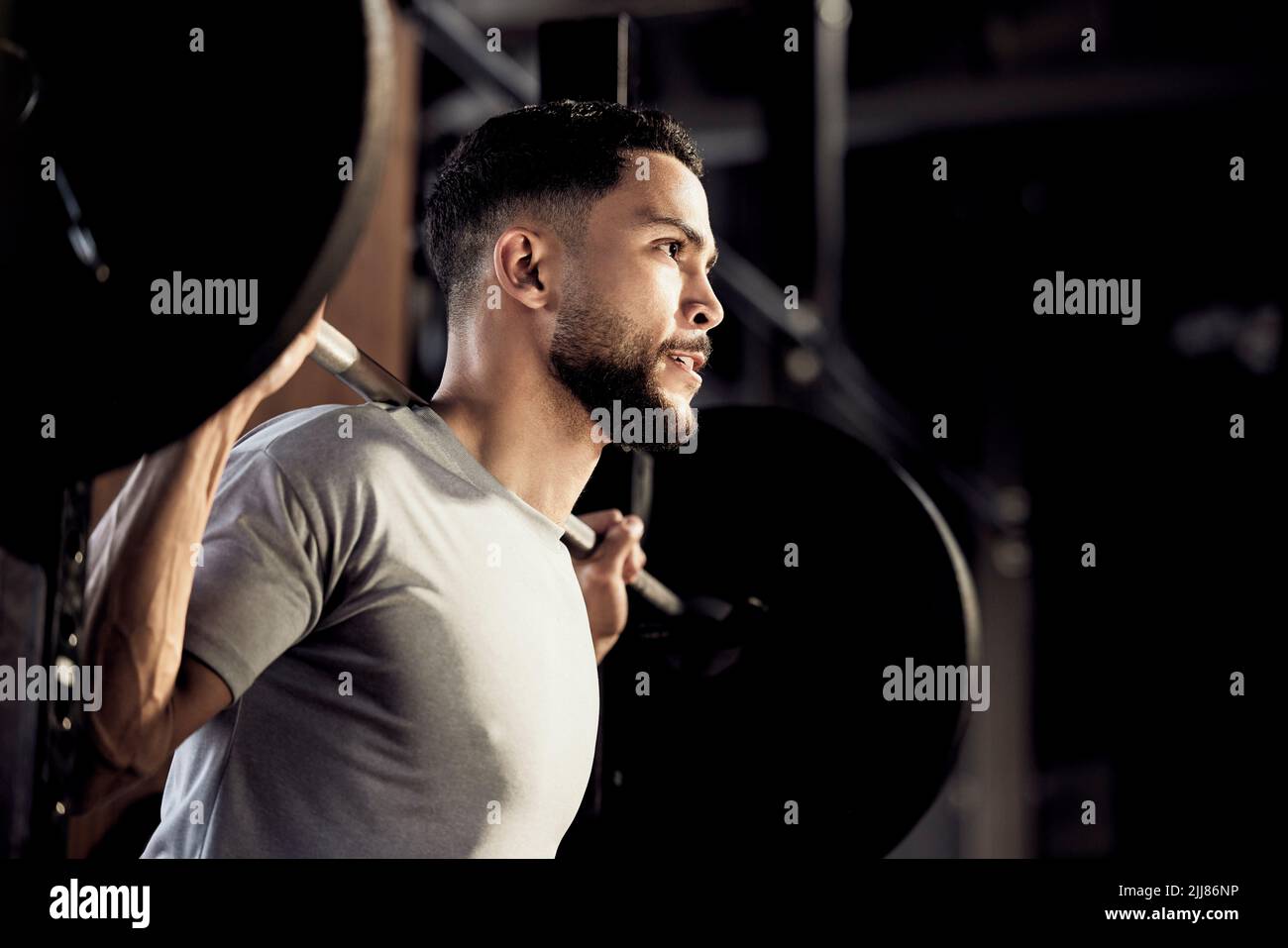 Keppa che spinge. Un giovane muscolare esercitarsi con un peso in una palestra. Foto Stock