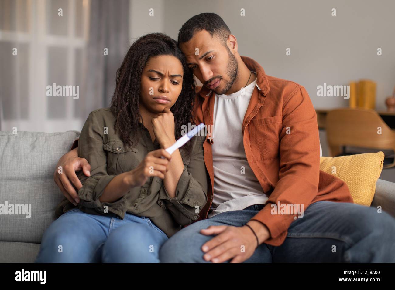 Depresso Black Couple Holding negative Pregnancy Test seduta a casa Foto Stock