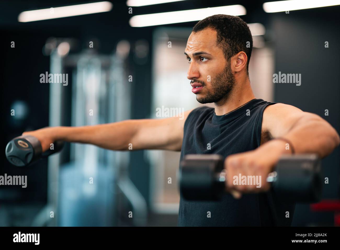Ritratto di motivato African American Male Athete Training con Dumbbells in palestra Foto Stock