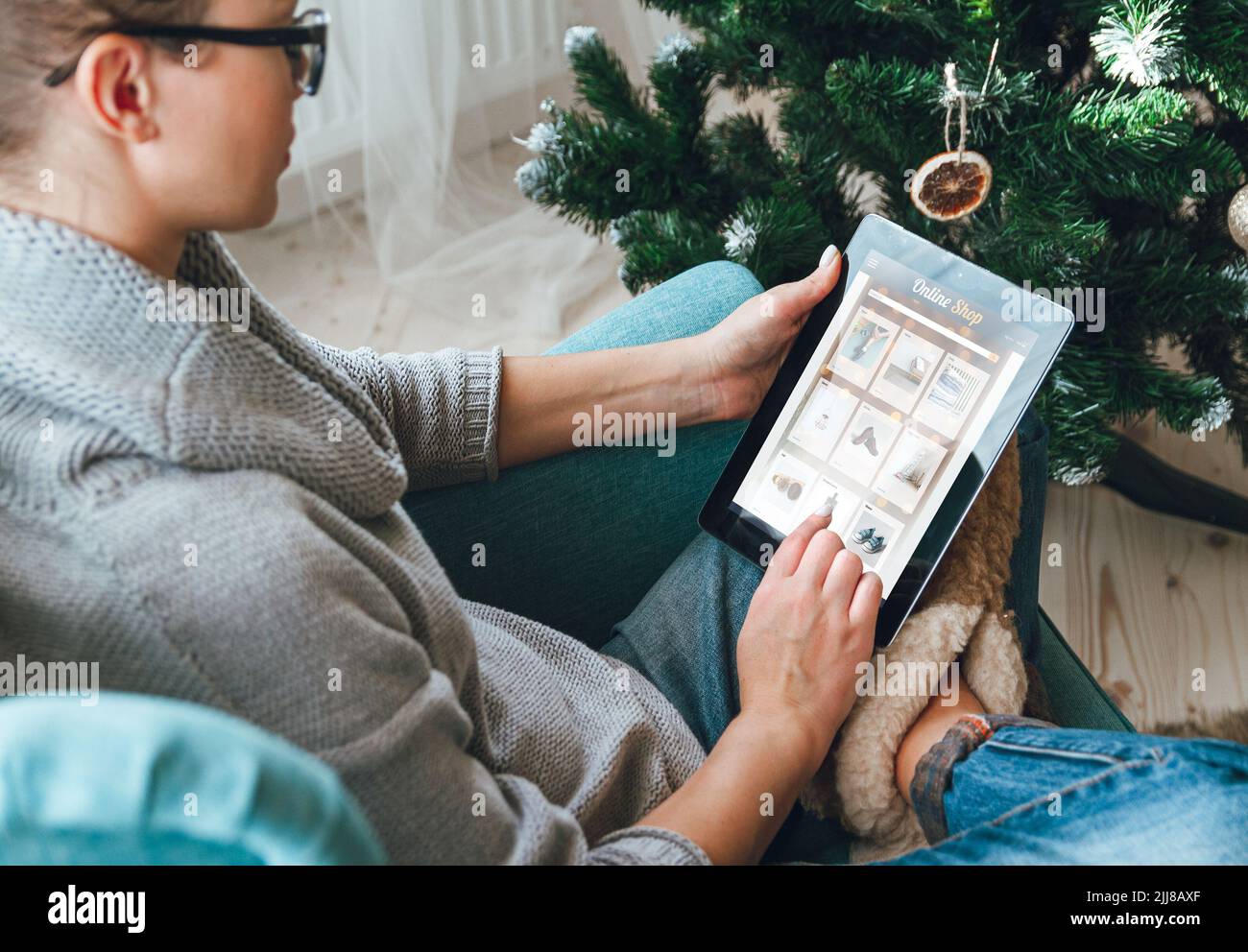 Giovane donna con tavoletta sullo sfondo di un albero di Natale Foto Stock
