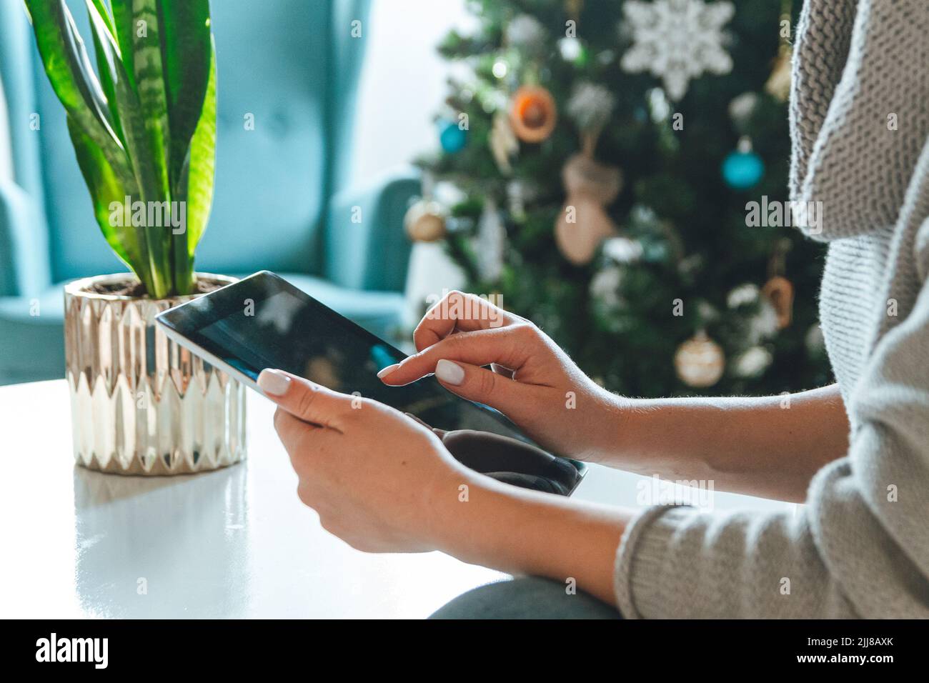 Giovane donna con tavoletta sullo sfondo di un albero di Natale Foto Stock