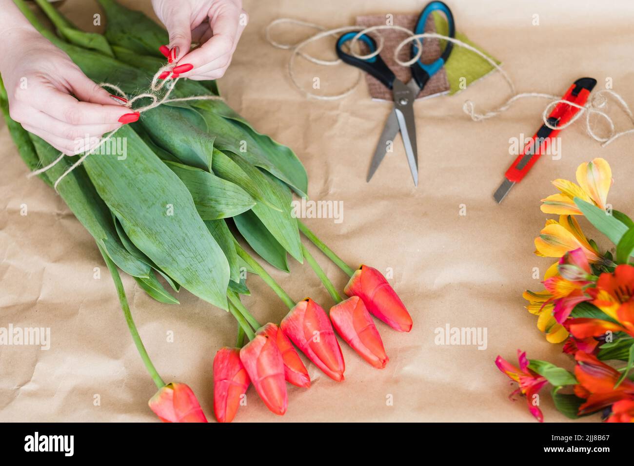 fiorista lavoro donna fiore bouquet rosso tulipano primavera Foto Stock