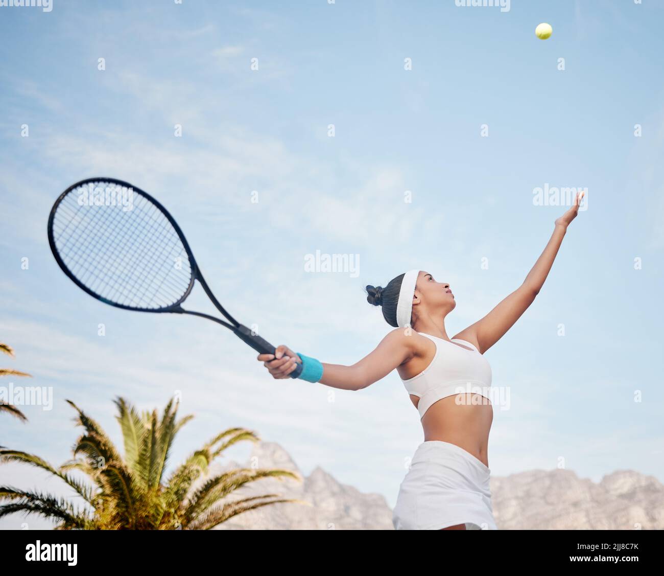 Lavorando al mio servizio oggi. Giovane giocatore di tennis in piedi da solo sul campo e servire la palla durante la pratica. Foto Stock