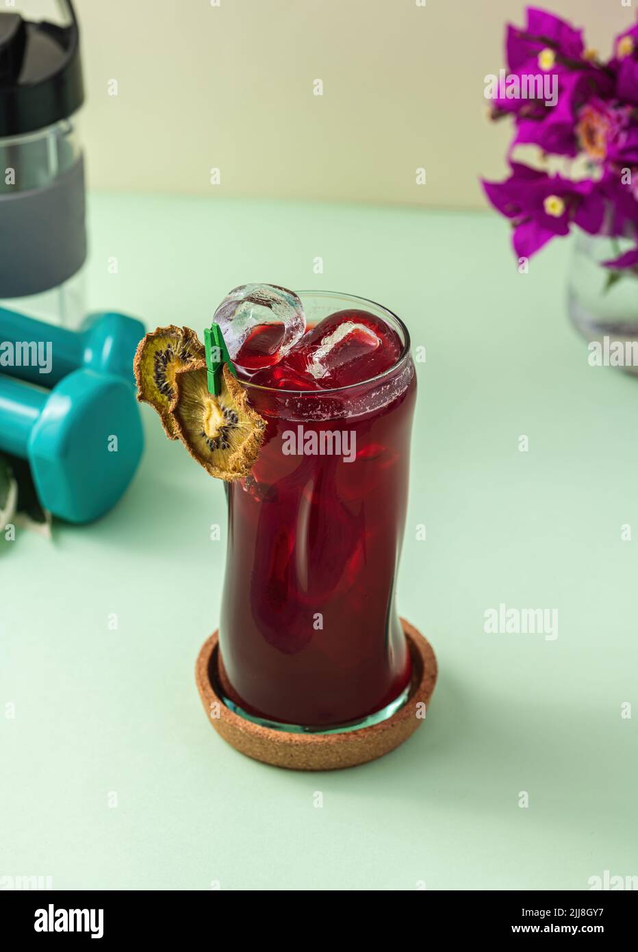 Rinfrescante bevanda salutare in una lunga tazza di vetro su sfondo verde chiaro Foto Stock