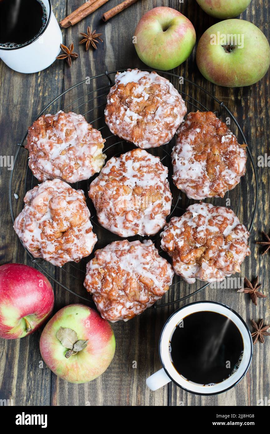 Flatlay di frittelle di mele glassate e caffè nero fresco con mele fresche, corteccia di cannella e anice. Vista dall'alto. Foto Stock