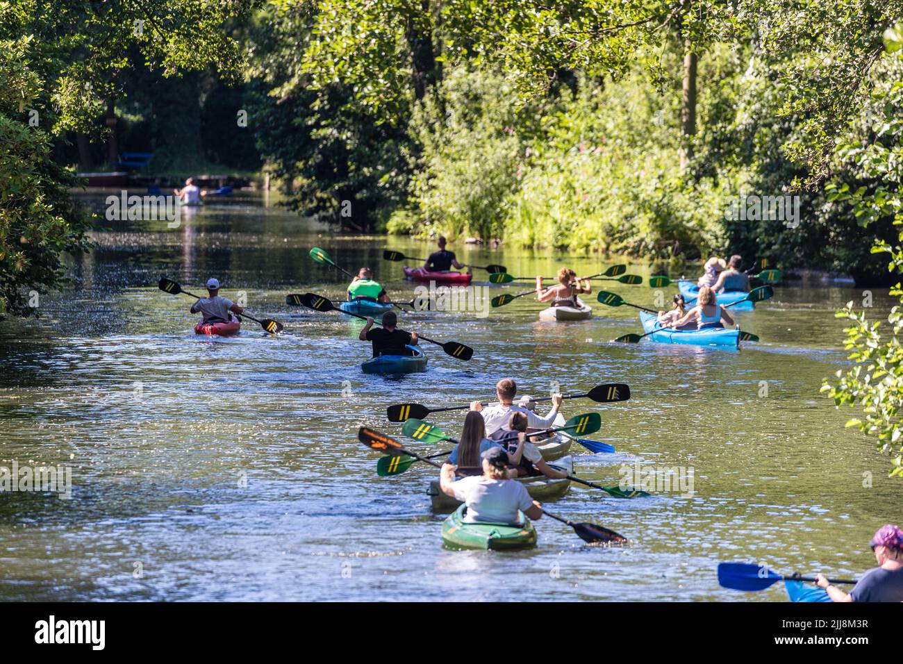 23 marzo 2022, Brandeburgo, Lübbenau: La gente pagaia in canoe su un fiume Spreewald vicino a Lübbenau. La siccità delle ultime settimane non ha ancora provocato un calo visibile del livello delle acque dei fiumi Spreewald. Le chiatte Spreewald, che hanno una lunghezza di circa 30 centimetri quando sono completamente occupate, possono ancora essere addlate attraverso le acque senza alcun problema. Foto: Frank Hammerschmidt/dpa Foto Stock