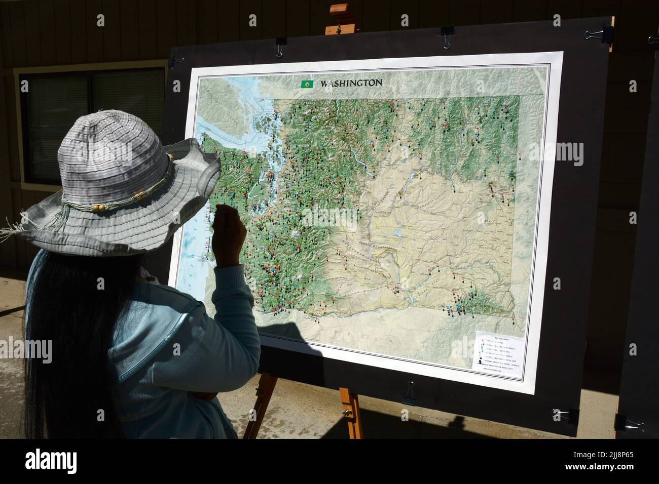 Donna che guarda una mappa che mostra le località degli avvistamenti di Sasquatch in mostra al Metaline Falls Bigfoot Festival, nello stato di Washington, USA. Foto Stock