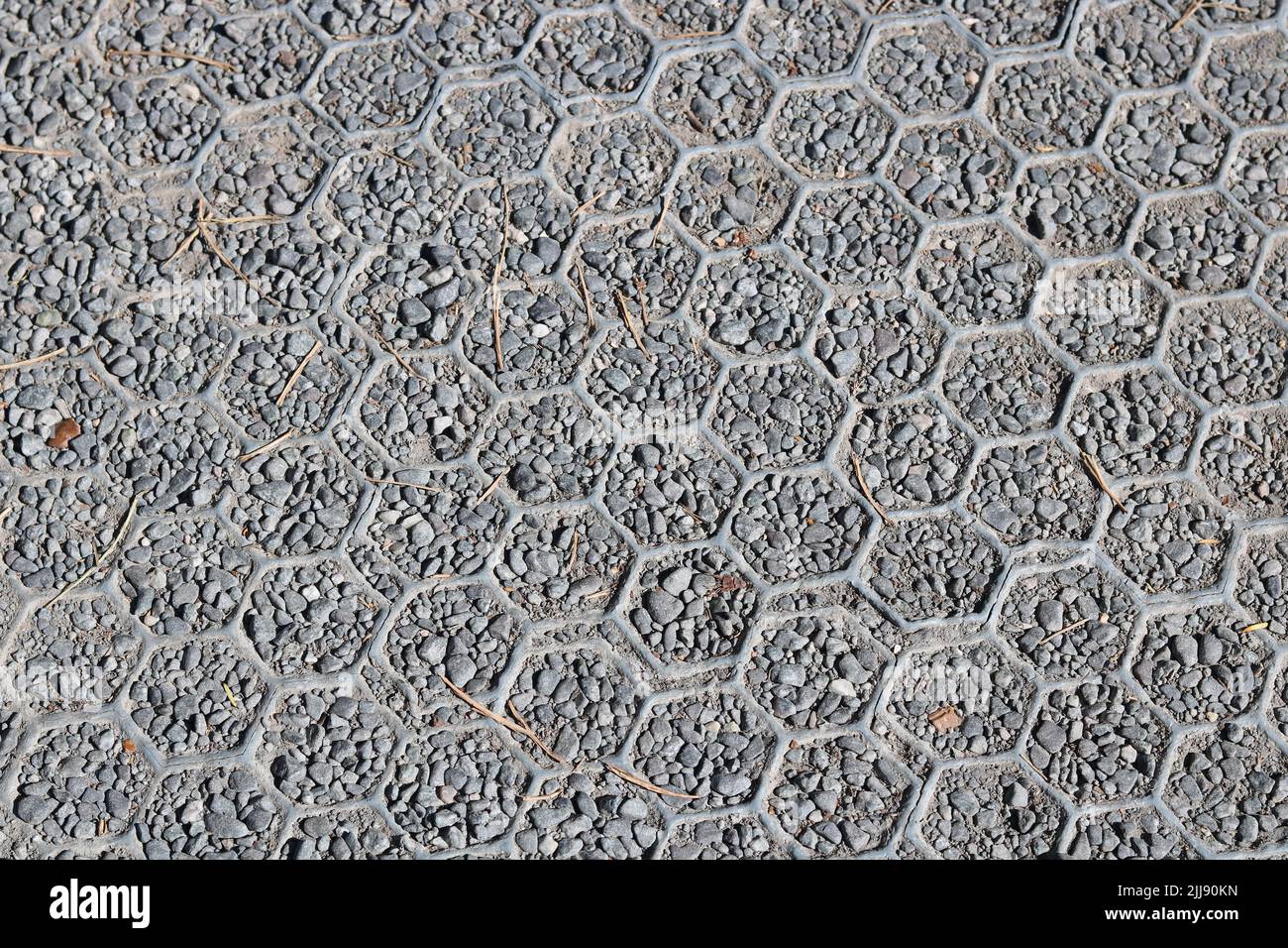 Plastica e ghiaia induriti sull'erba con design esagonale - immagine Foto Stock