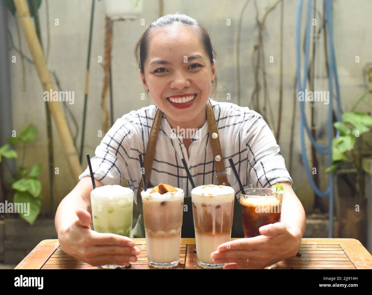 La cameriera asiatica ha preparato delle bevande da servire in una caffetteria Foto Stock